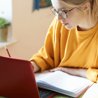 Woman studying with computer and notebook