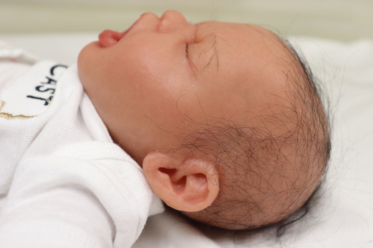 Close up of a baby manikin's head with hair detail.