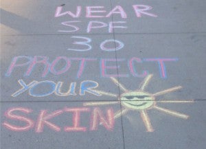 "Wear SPF 30 Protect Your Skin" Written on a sidewalk