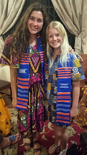 Abbey and Megan posing in blue and orange kente cloth