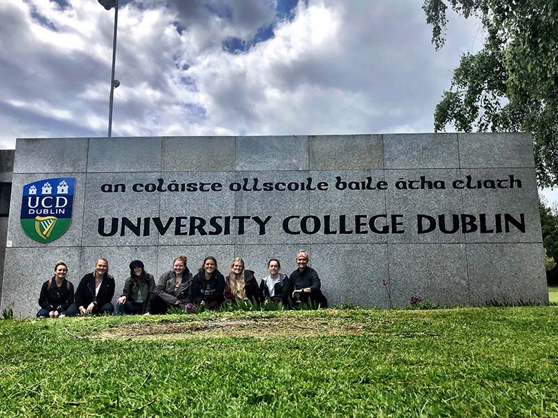 A photo of all 8 students who went to Ireland posing in front of the University College Dublin