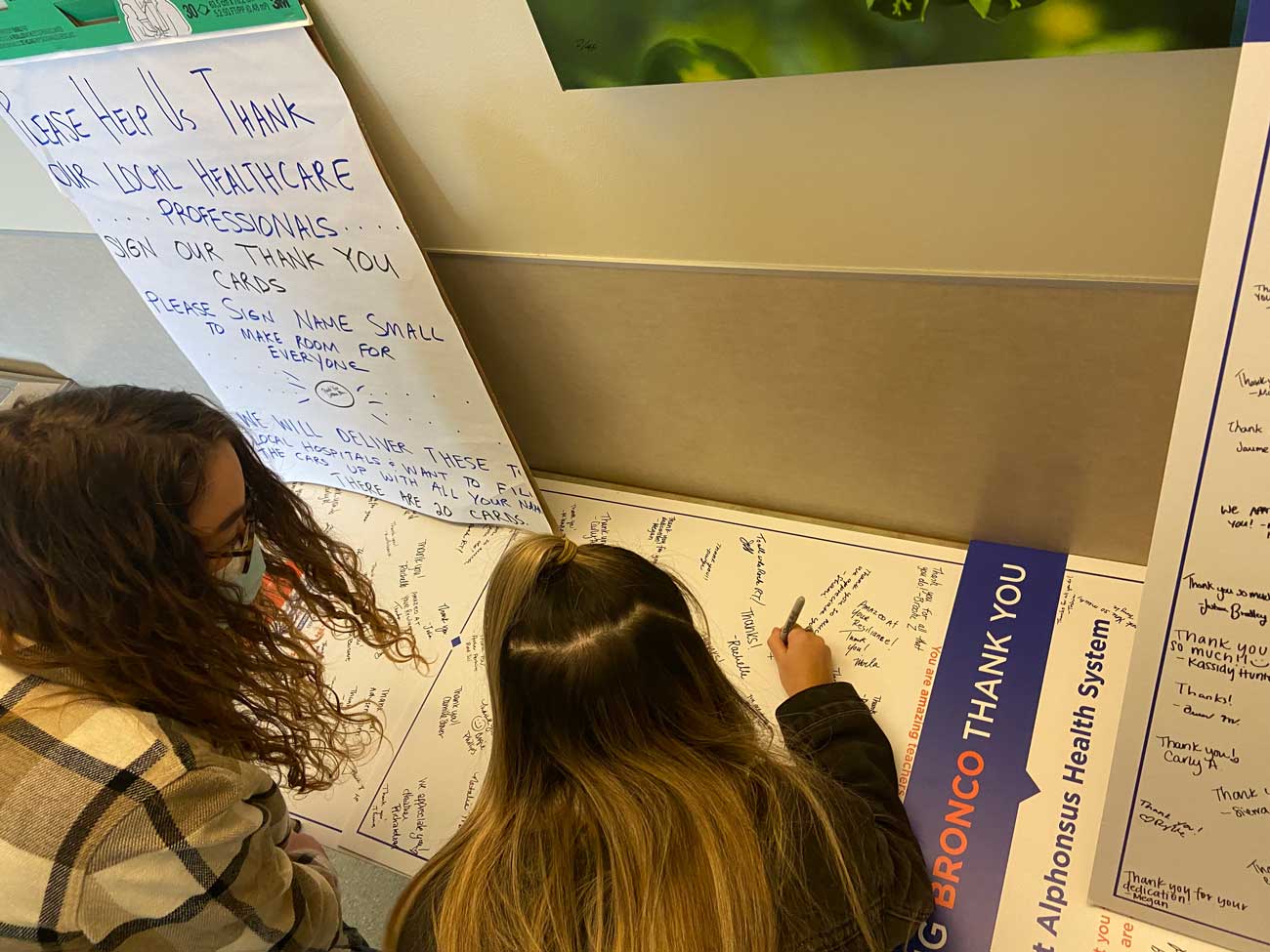 Students sign giant thank you card for health care professionals