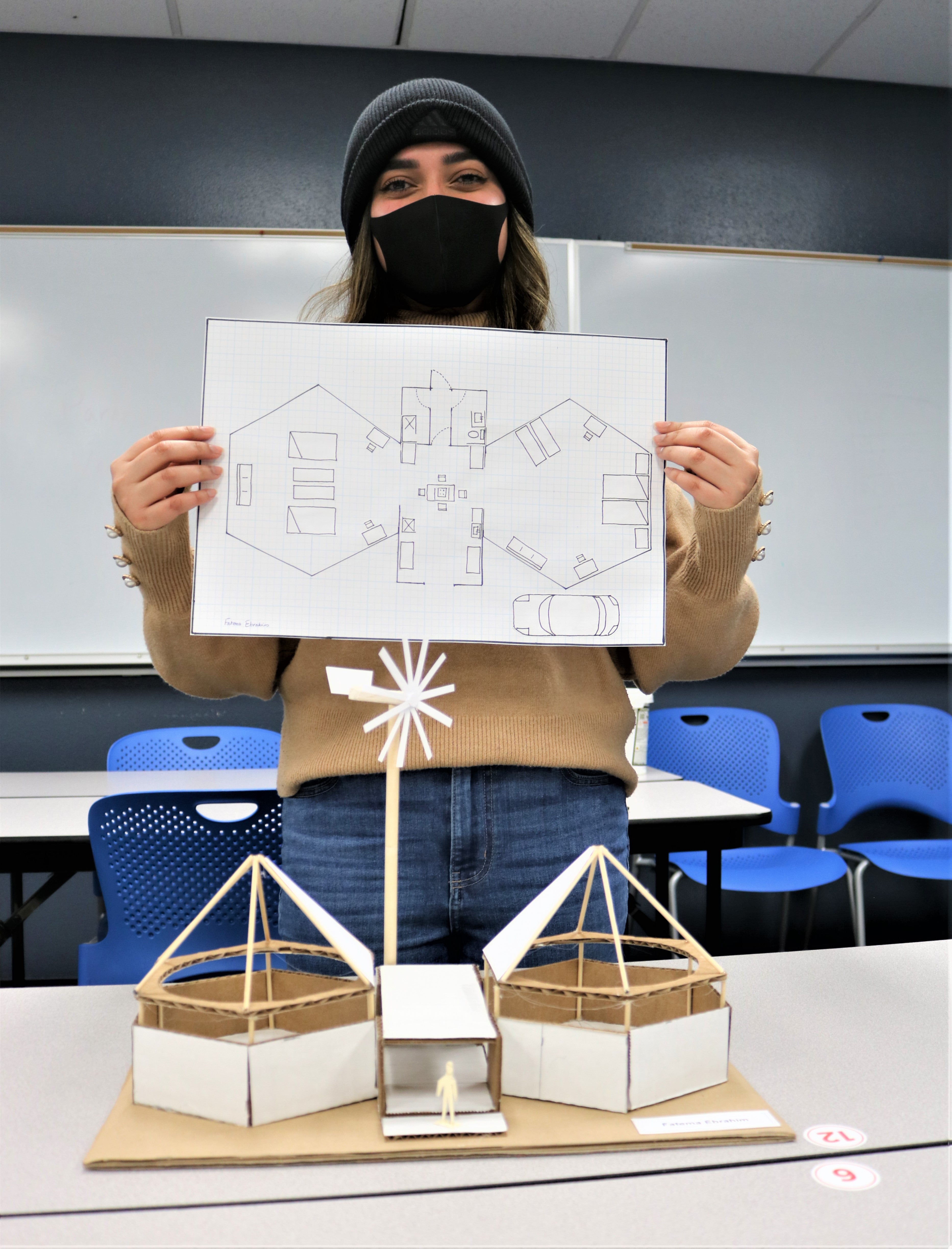 Ebrahim holds up paper design for model