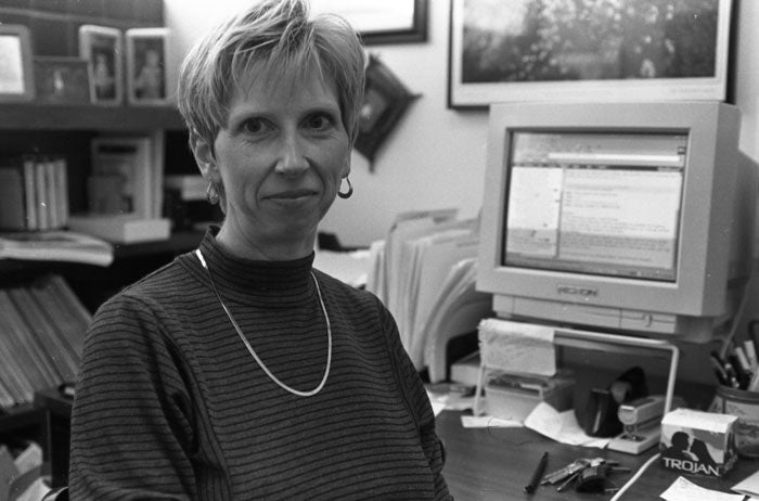 Black and white image of Pam Gehrke at her computer in her office in the 1990's