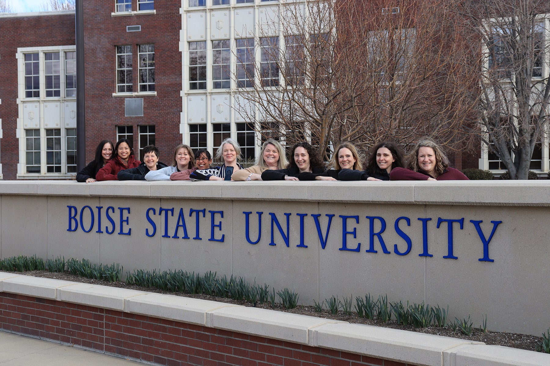 The 2022 doctoral cohort stand by the Boise State University sign.