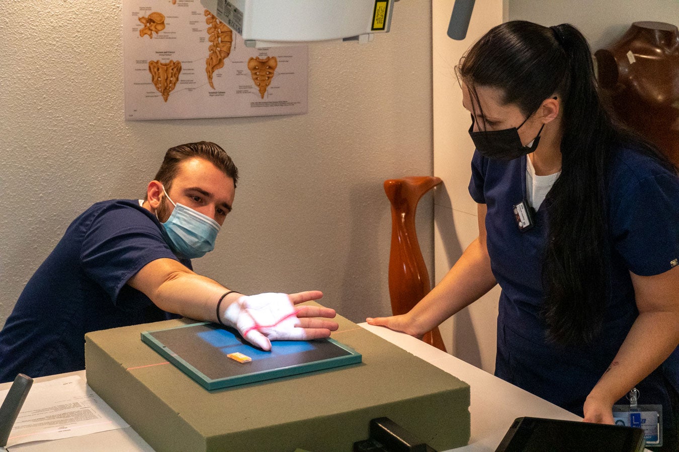 Boise State Radiologic Sciences students (Vitaliy Goretoy and Toshia Harke) practice positioning a thumb during a lab.