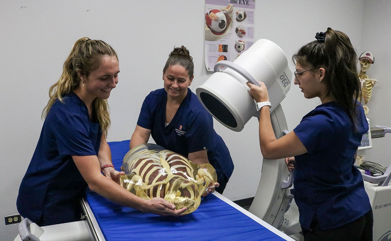 Radiologic Sciences students position the new C-arm on model torso