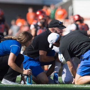 Football AT students helping player