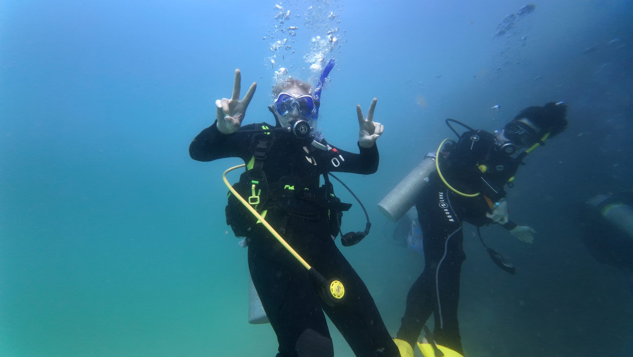 Katie Lysne navigates underwater in full scuba gear.