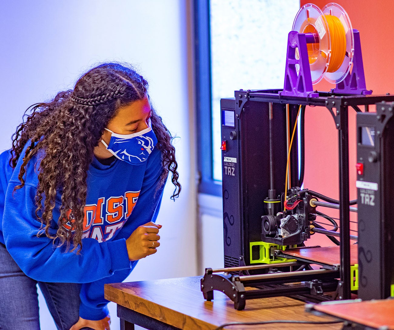 Student bending forward looking at equipment