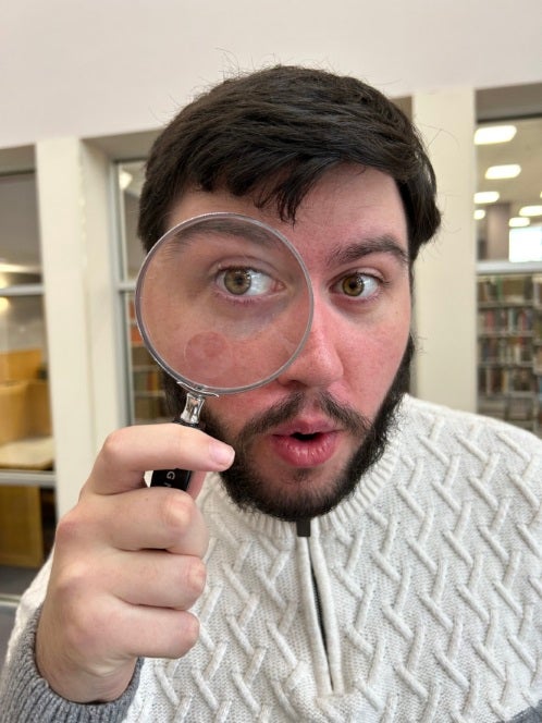 photo of man holding magnifying glass