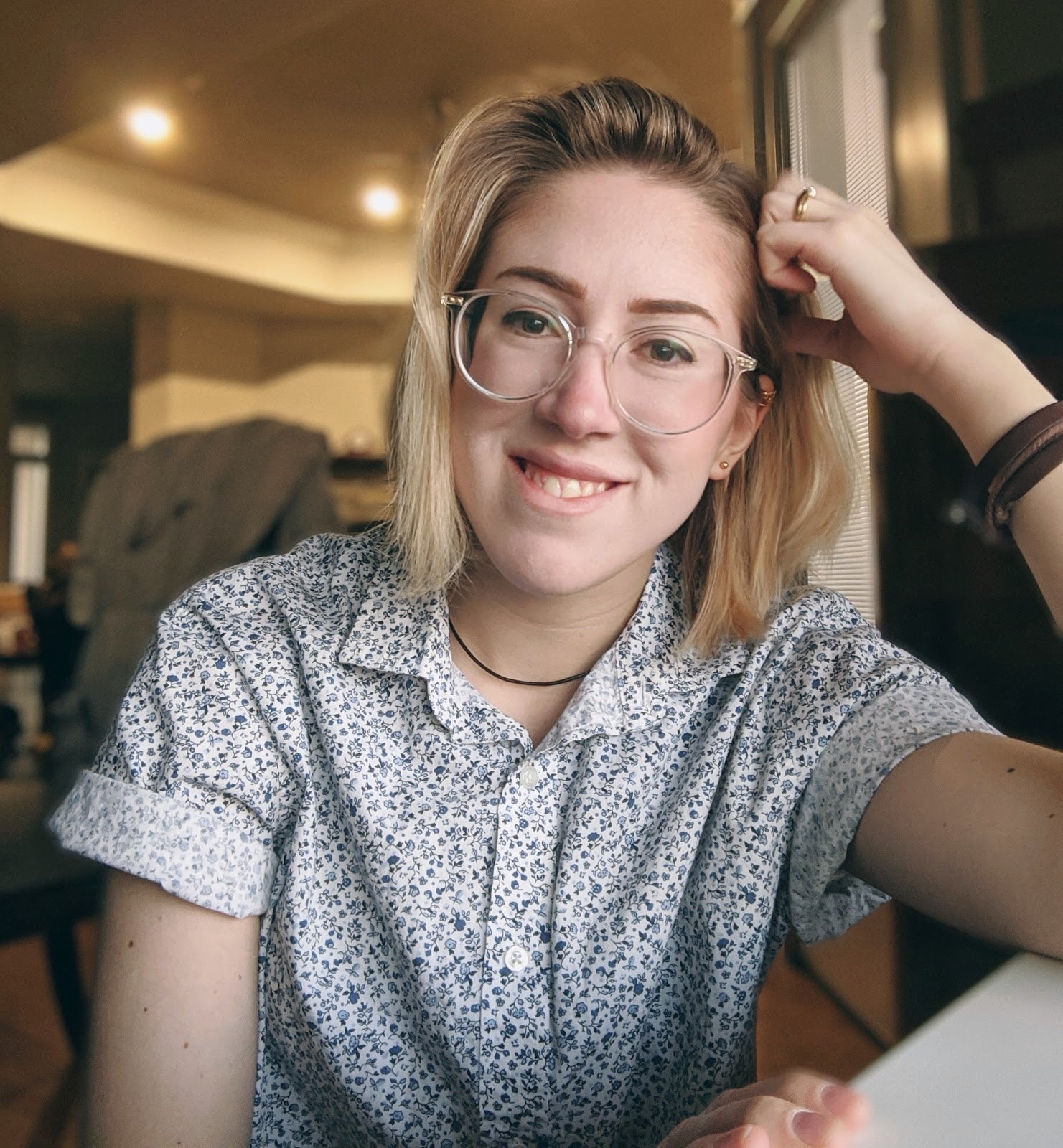 young woman with glasses smiling supporting her head with hand