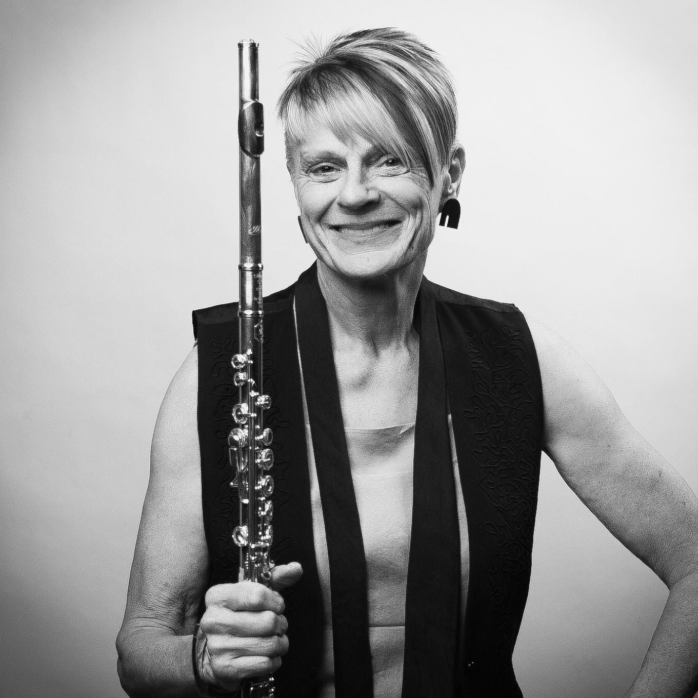 Black and white photo of Claudia Anderson holding her flute vertically.