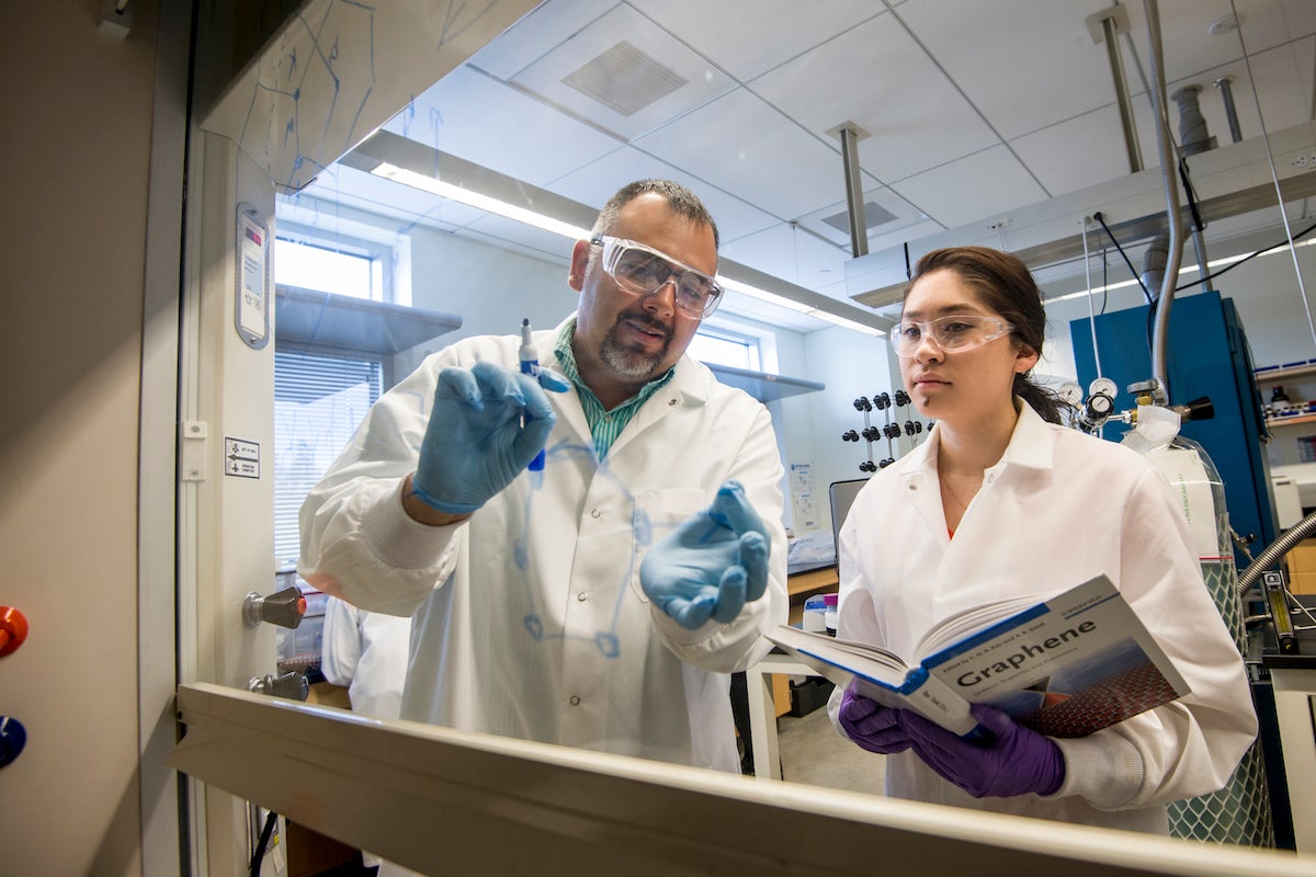 Photo of David Estrada with student in lab