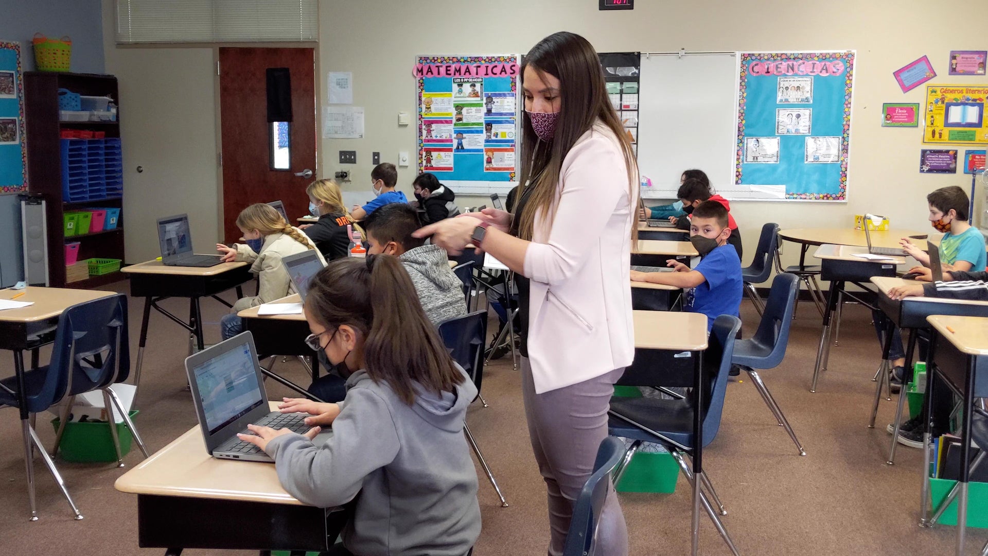 Students work on laptops in a classroom