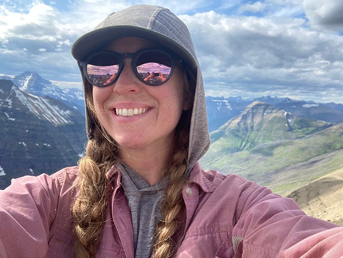 Jamie Faselt taking a selfie with a view of the mountains behind her