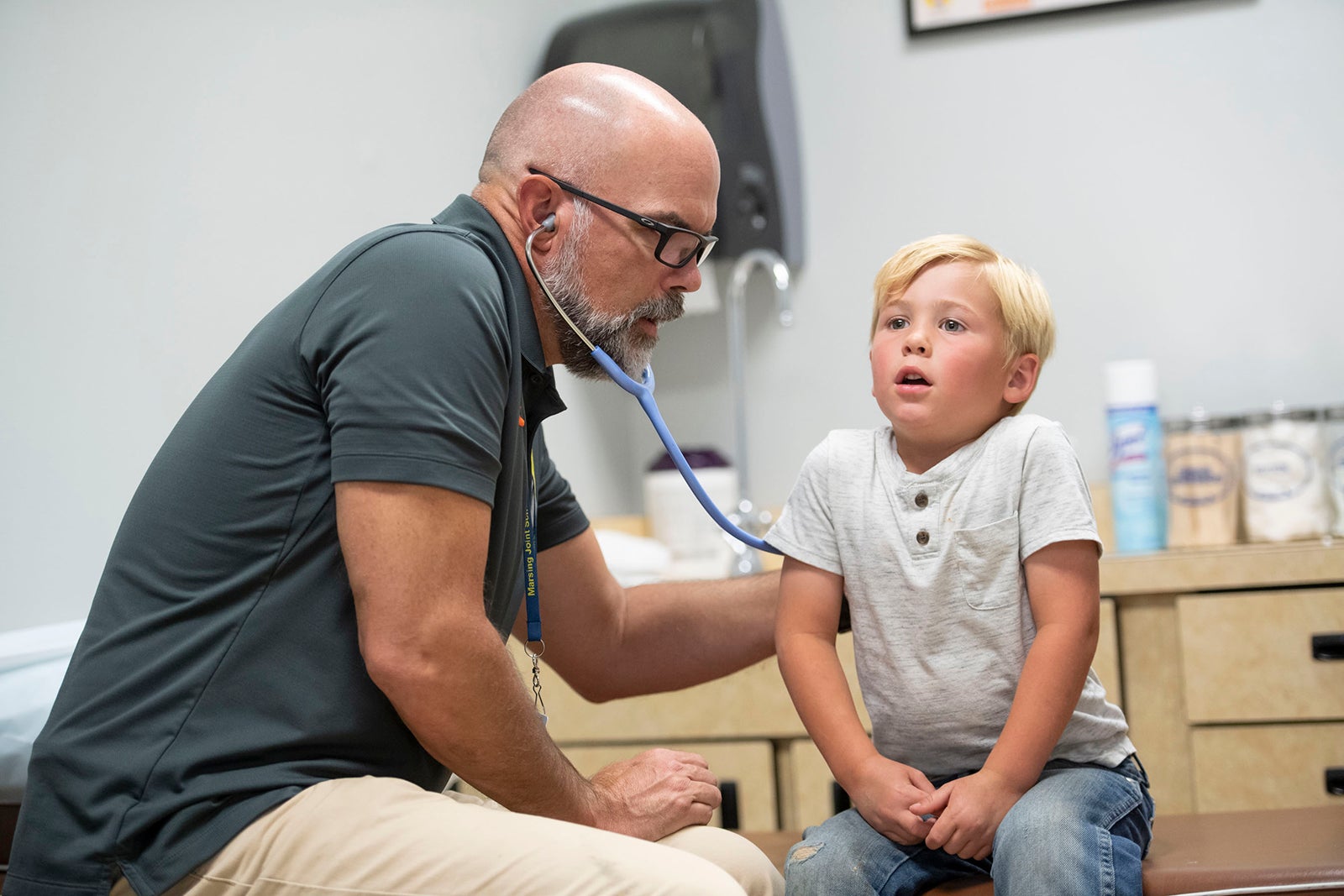 Max listens to a child's lungs using a stethoscope