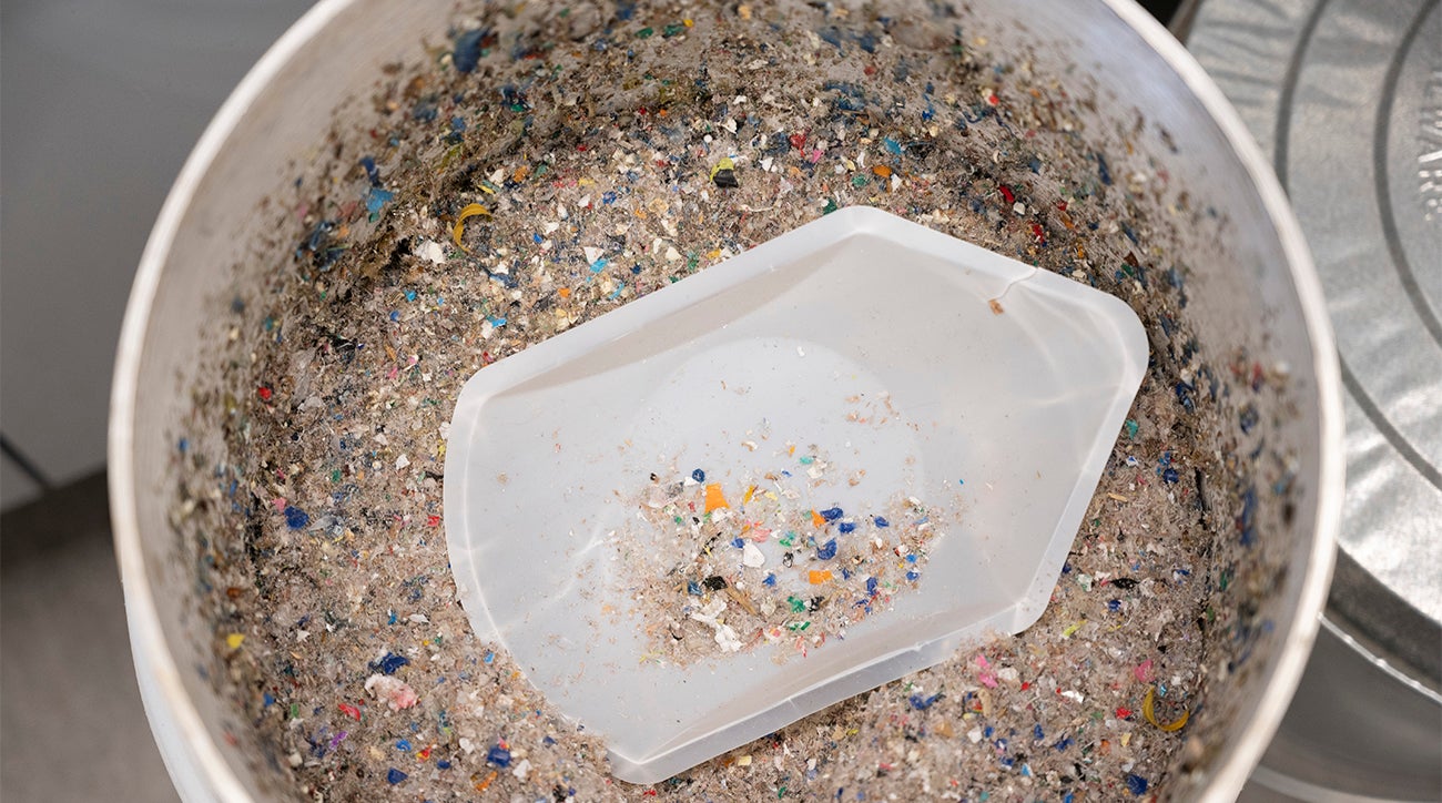 A bucket full of small pieces of broken down plastic