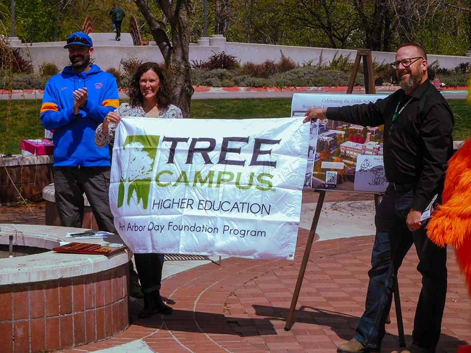 two people holds 'Tree Campus' sign