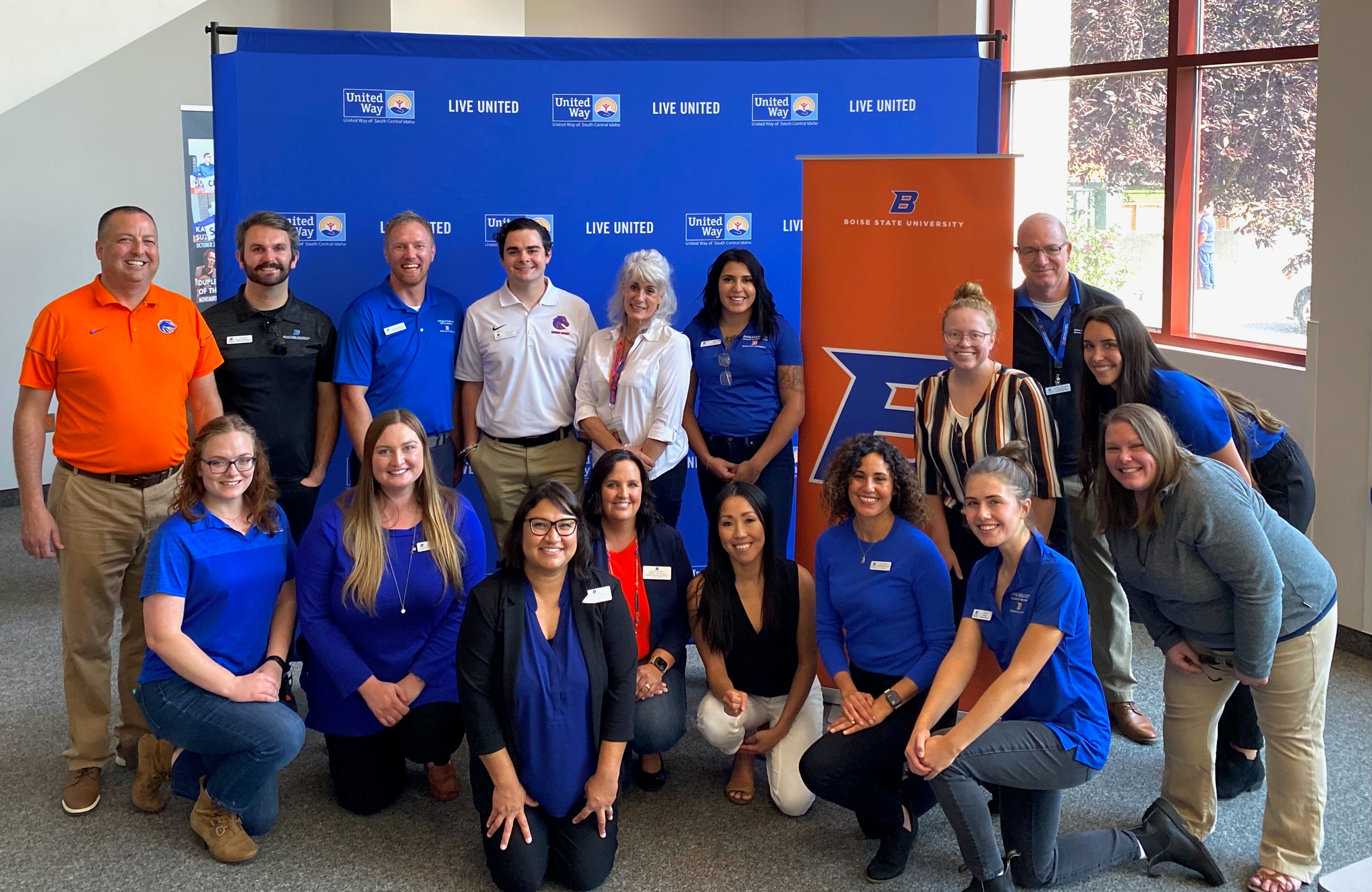 Boise State Day staff in a group in front of a blue photo backdrop. 