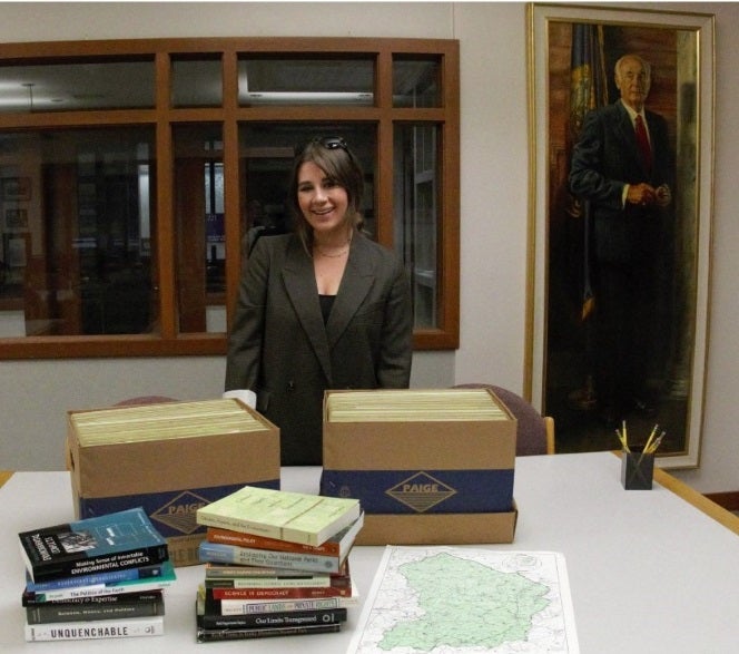 student with collection of books and papers