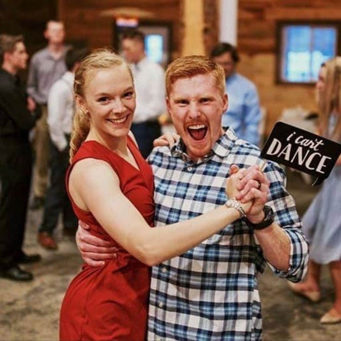 Hannah and Joseph Potter smile mid-dance with a sign that says "I can't dance"