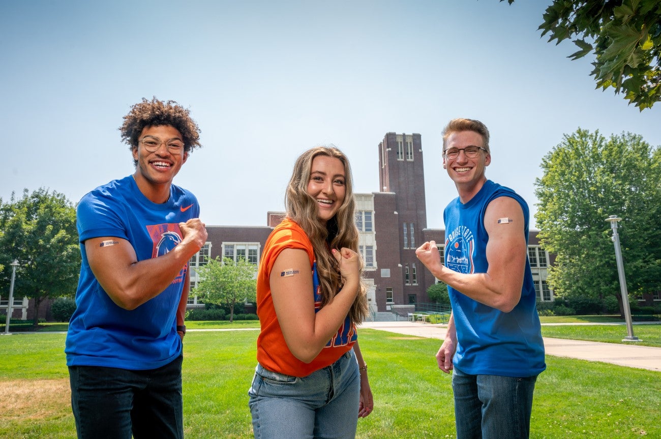 Students displaying vaccination band-aids