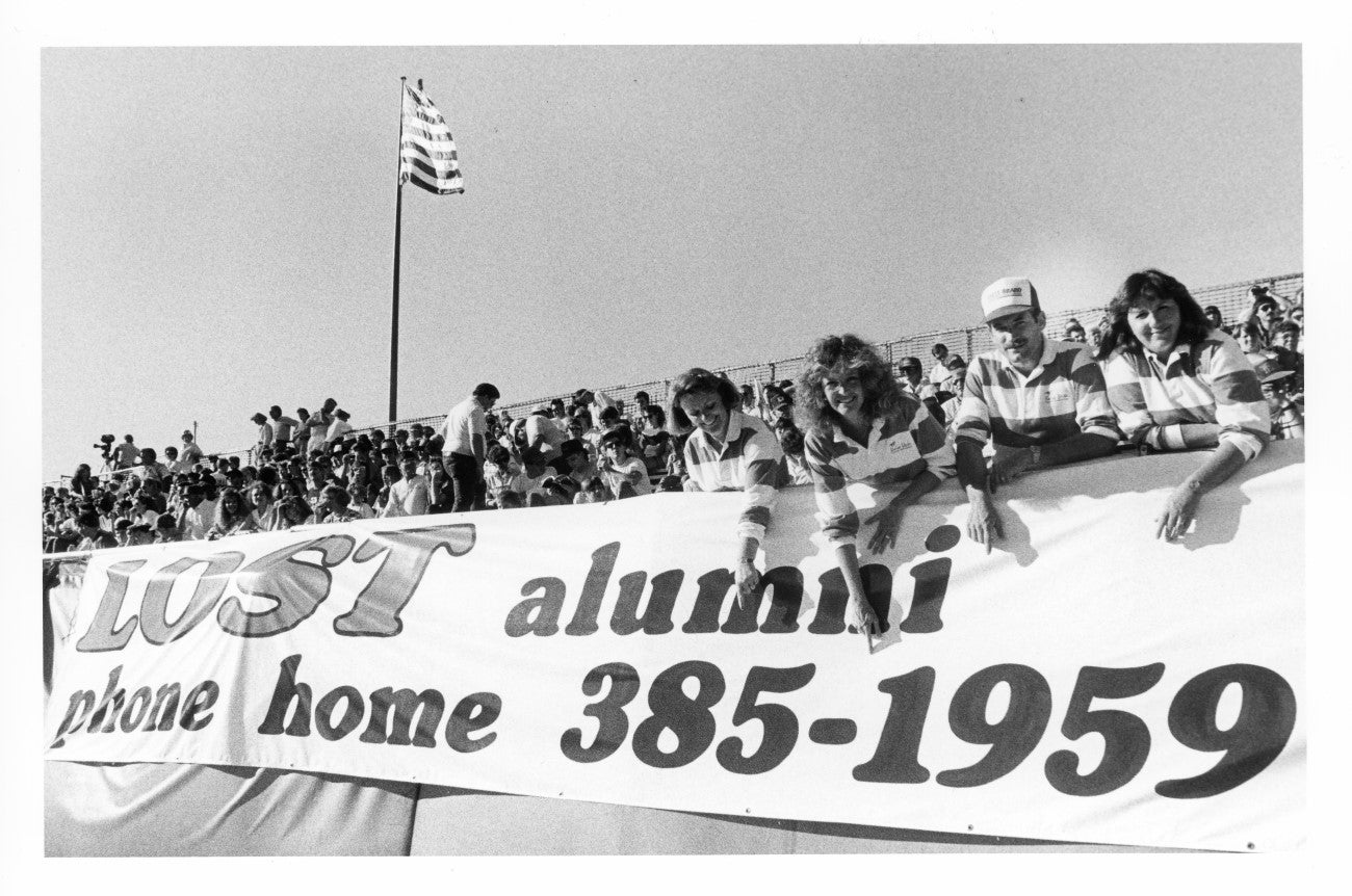 Students posing with alumni banner