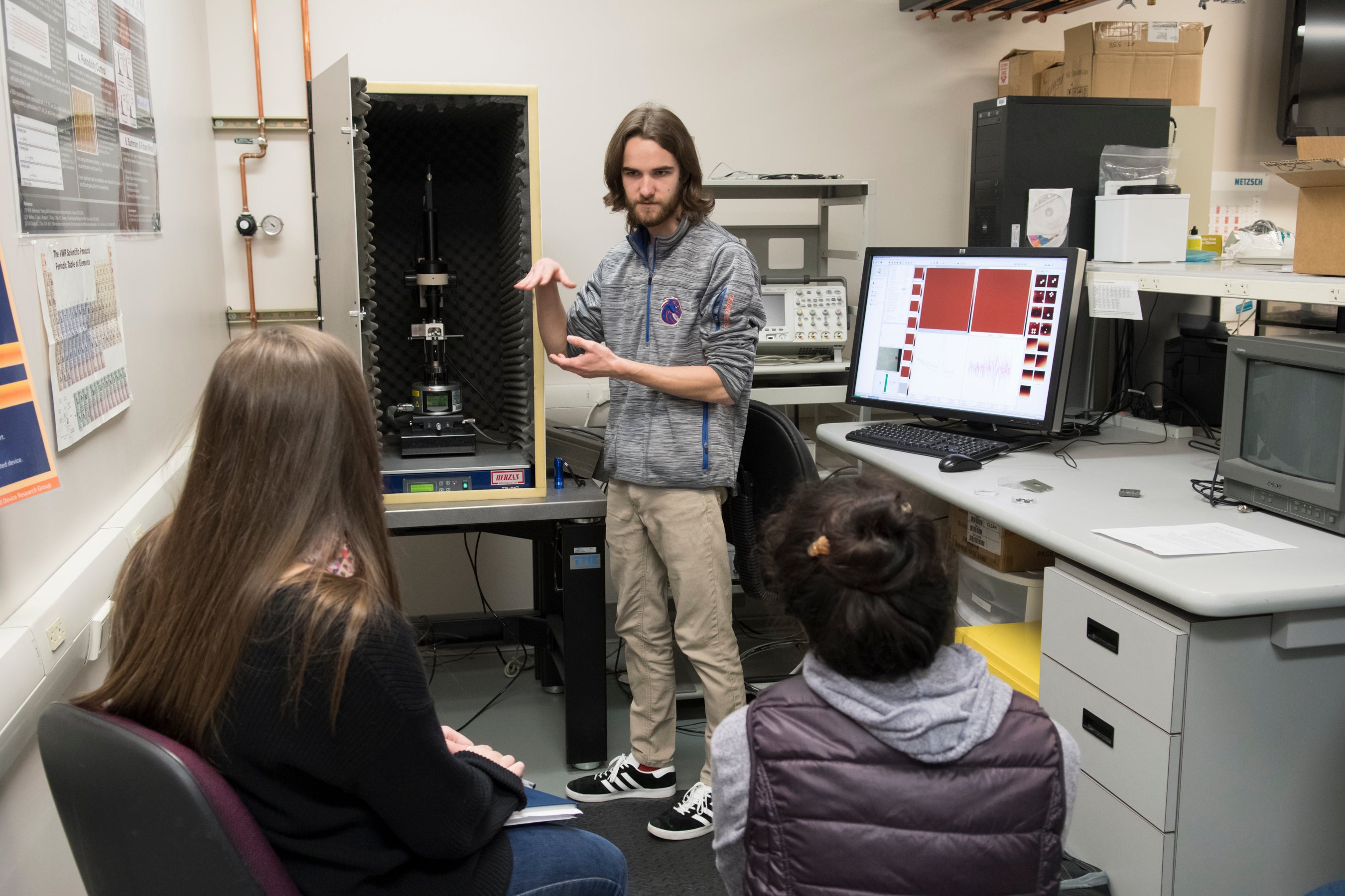 A student explains how a microscope works to other students