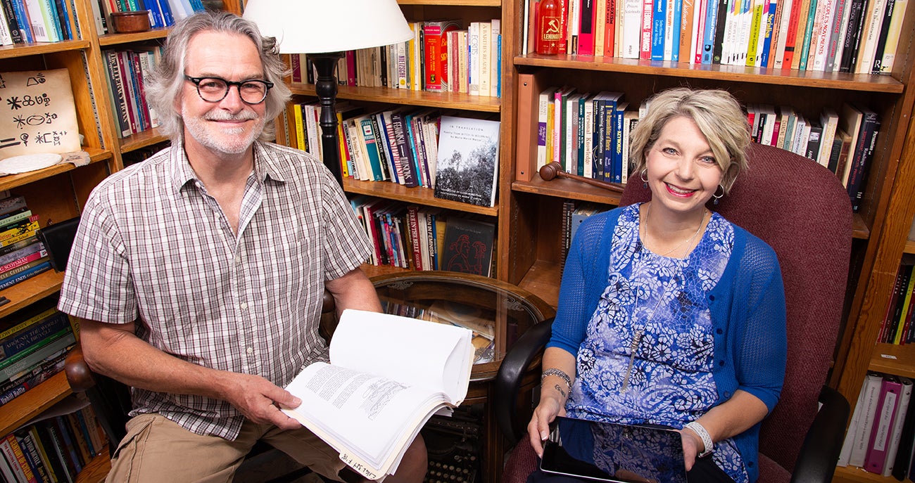 Two individuals are pictured holding a traditional textbook and an iPad.