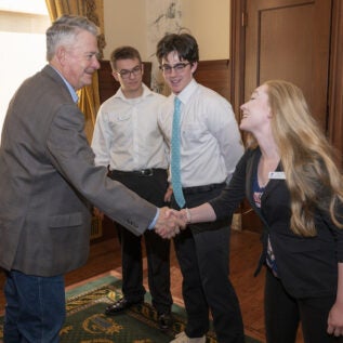 Idaho Governor shakes hands with students