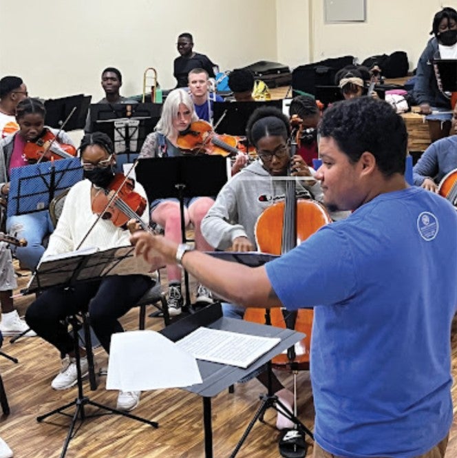 Kam JaCoby conducting student orchestra