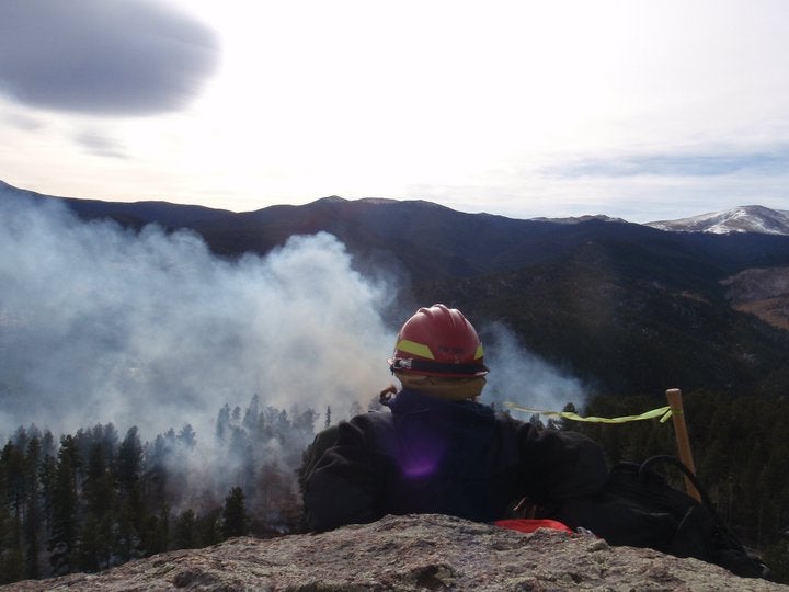 A firefighter watches a fire from above