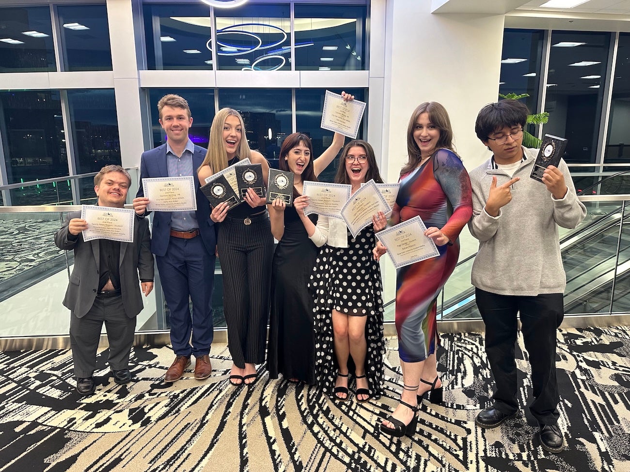 Students hold their awards