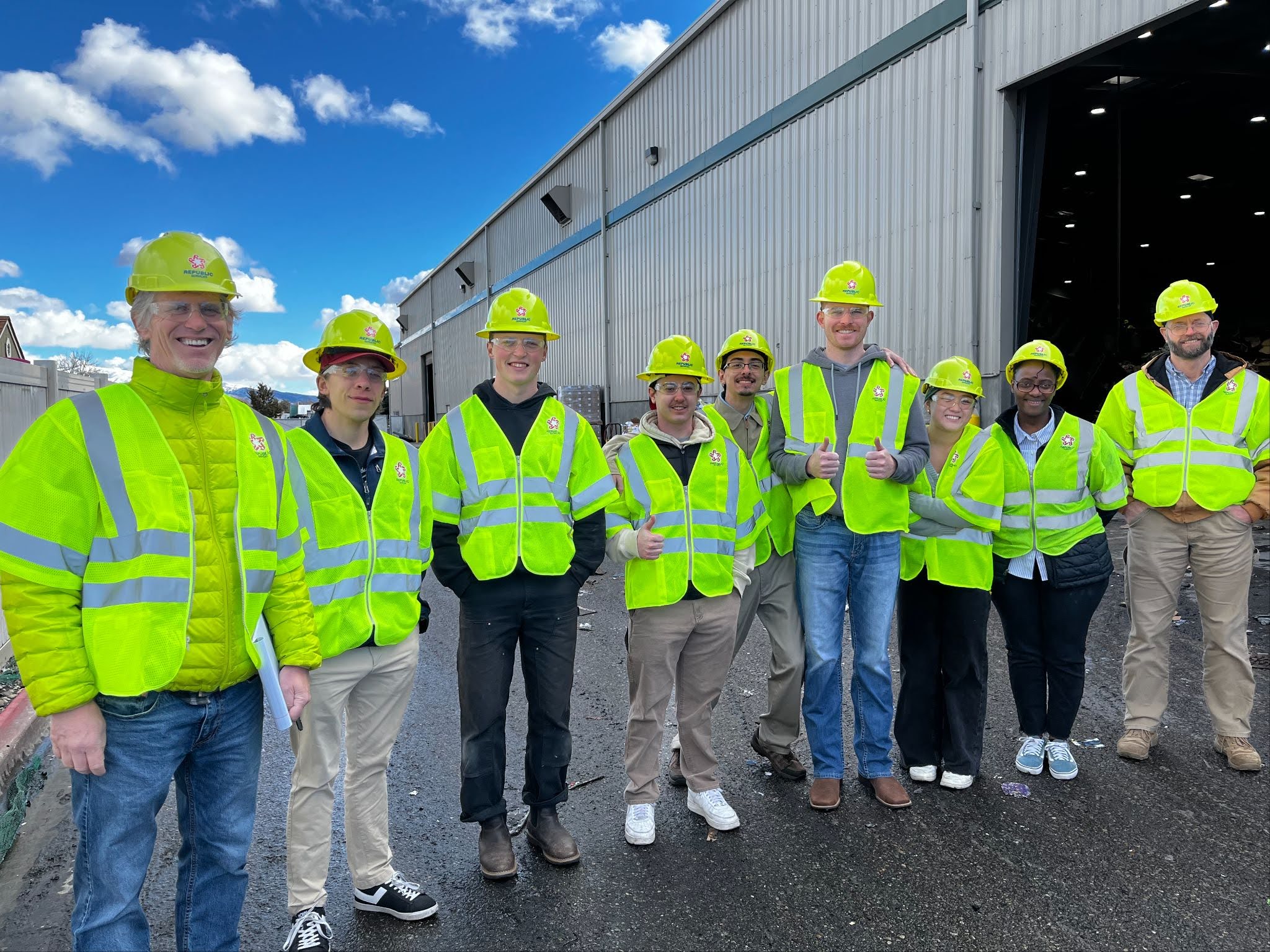 Students pose in hard hats and safety vests