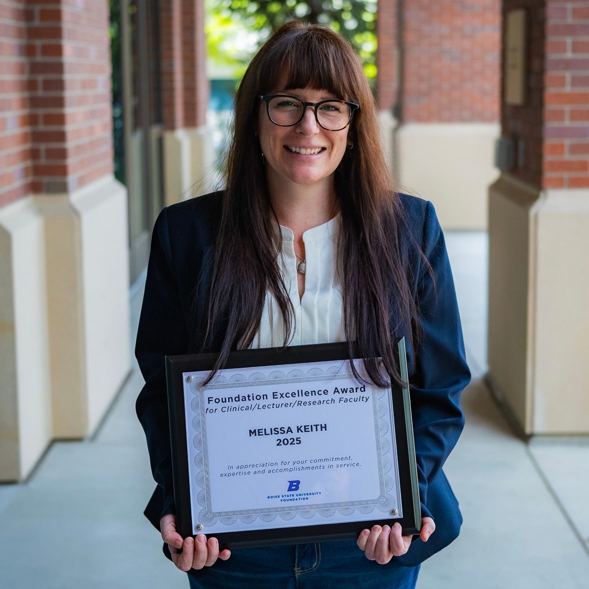 Melissa Keith poses with her Foundation Excellence Award certificate