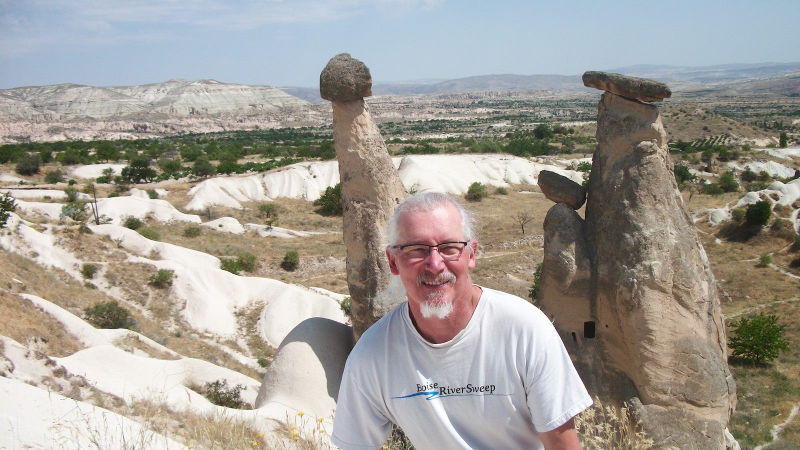 Photo of man in front of rock outcroppings
