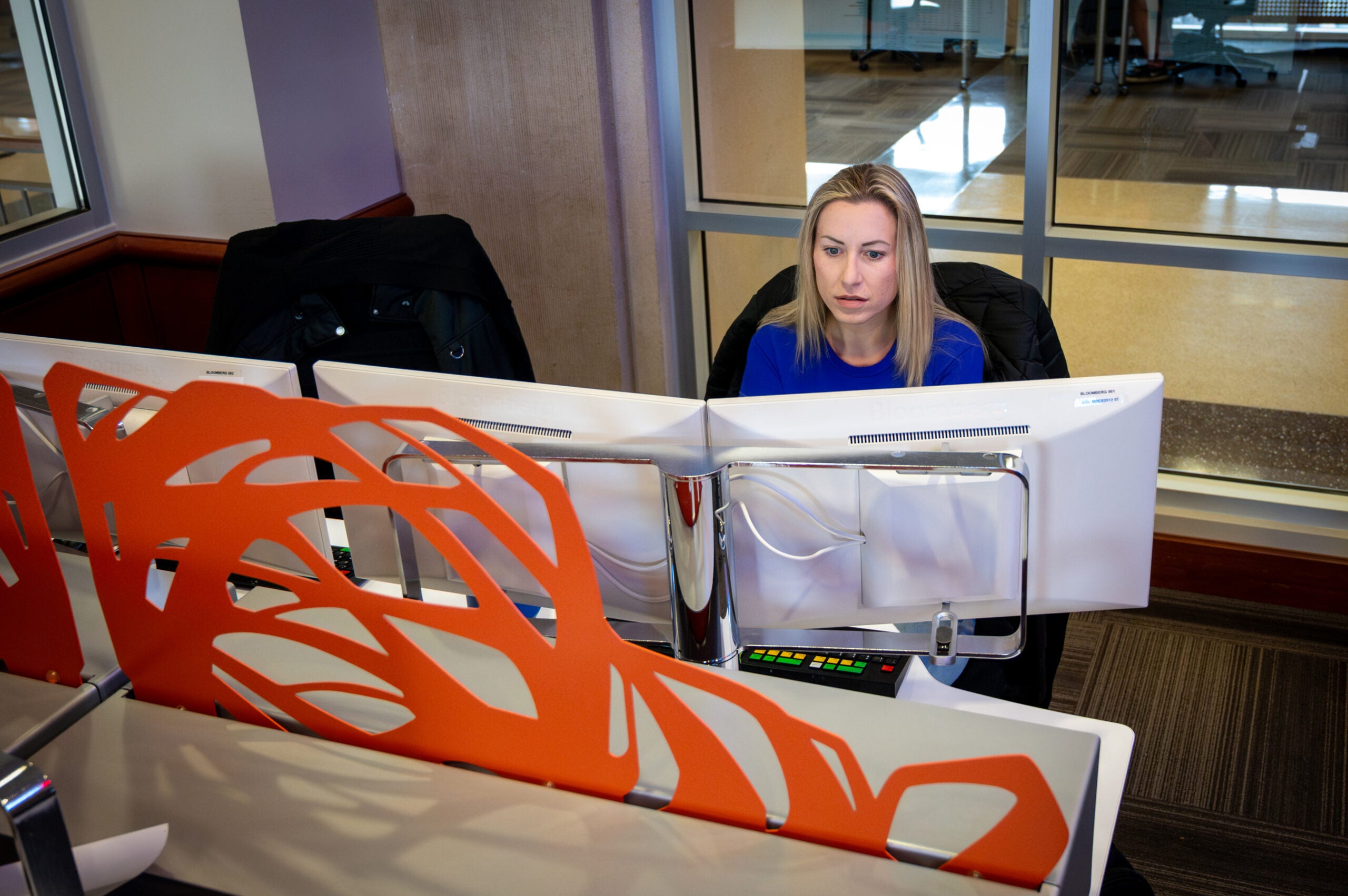 A person sits at a computer monitor in an office