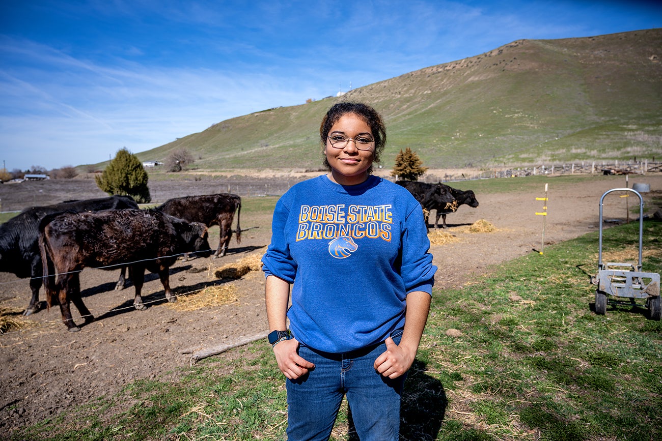 Sofia Sanchez-Chapman standing on her farm in front of cattle.