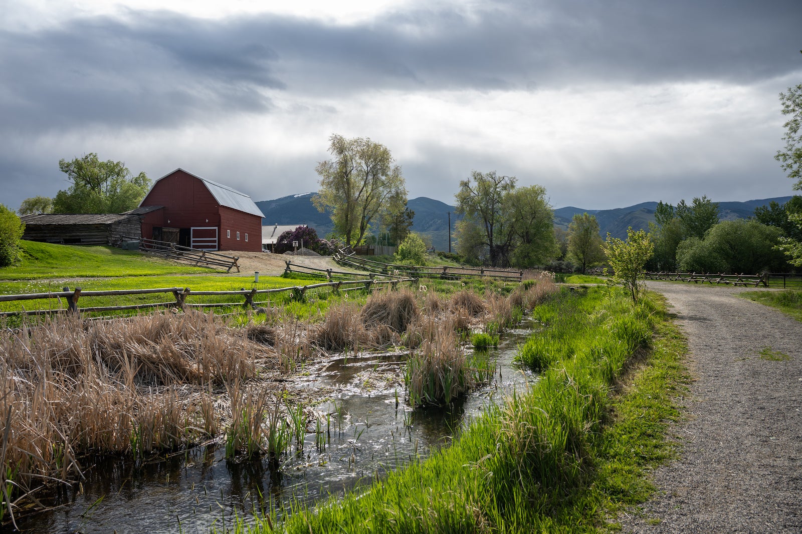 landscape photo showing red barn against mountain range