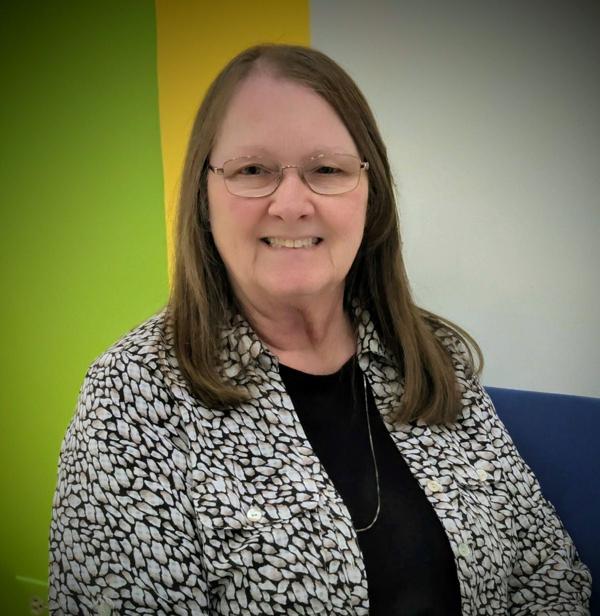 Headshot of Lorenda Hall, a woman wearing glasses and a black and white shirt