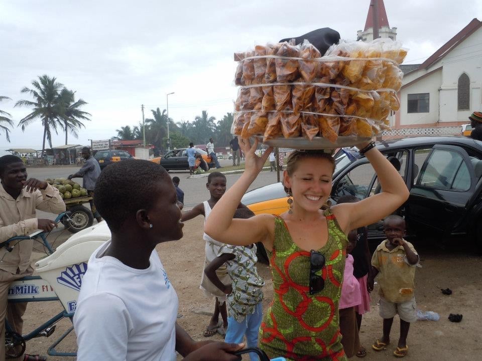 Amanda Timoney balances a large parcel on her head in an African street.