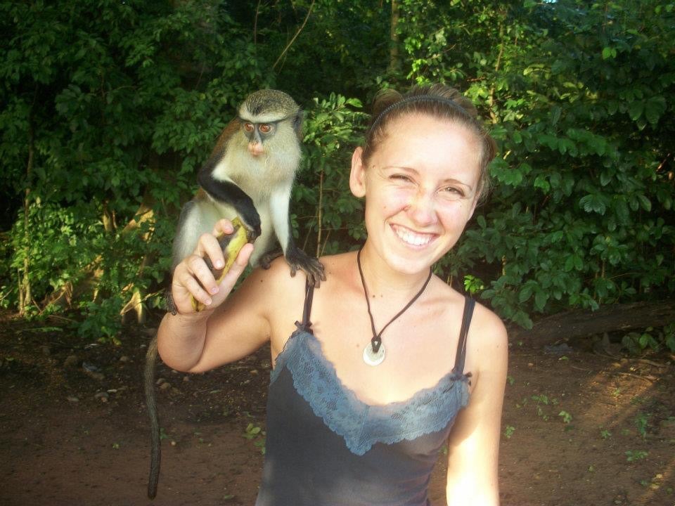 Amanda Timoney holds a monkey on her shoulder in Africa.