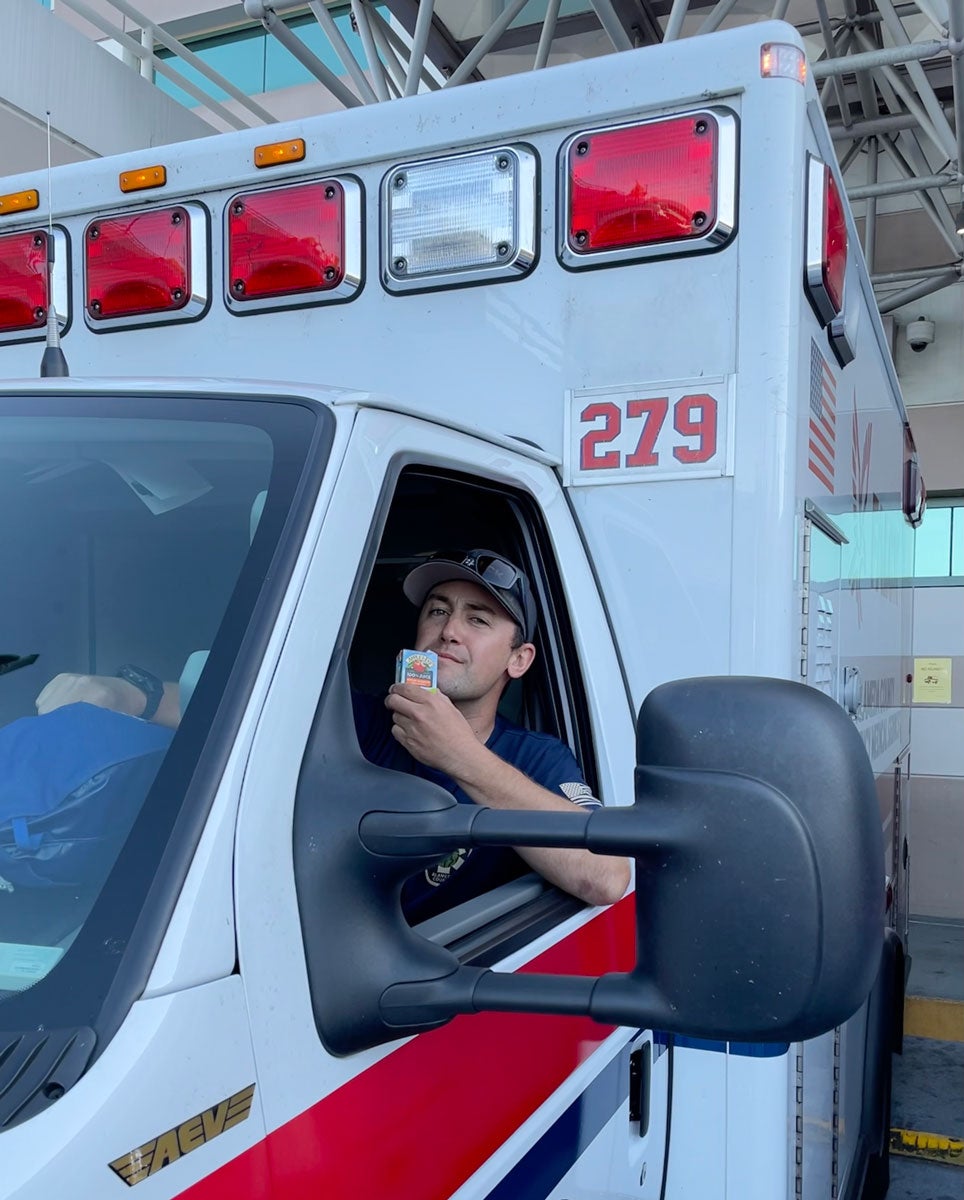 Dane Larson sips a juice box behind the wheel of an ambulance.