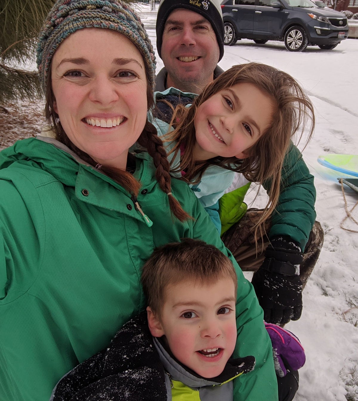 Margaret Quatraro smiles outdoors in the snow with her husband, daughter and son.