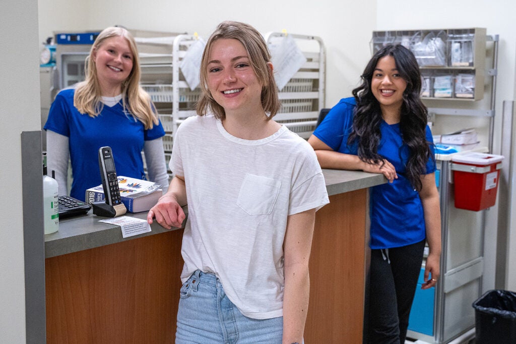 Three students in the Simulation Center nurses station.