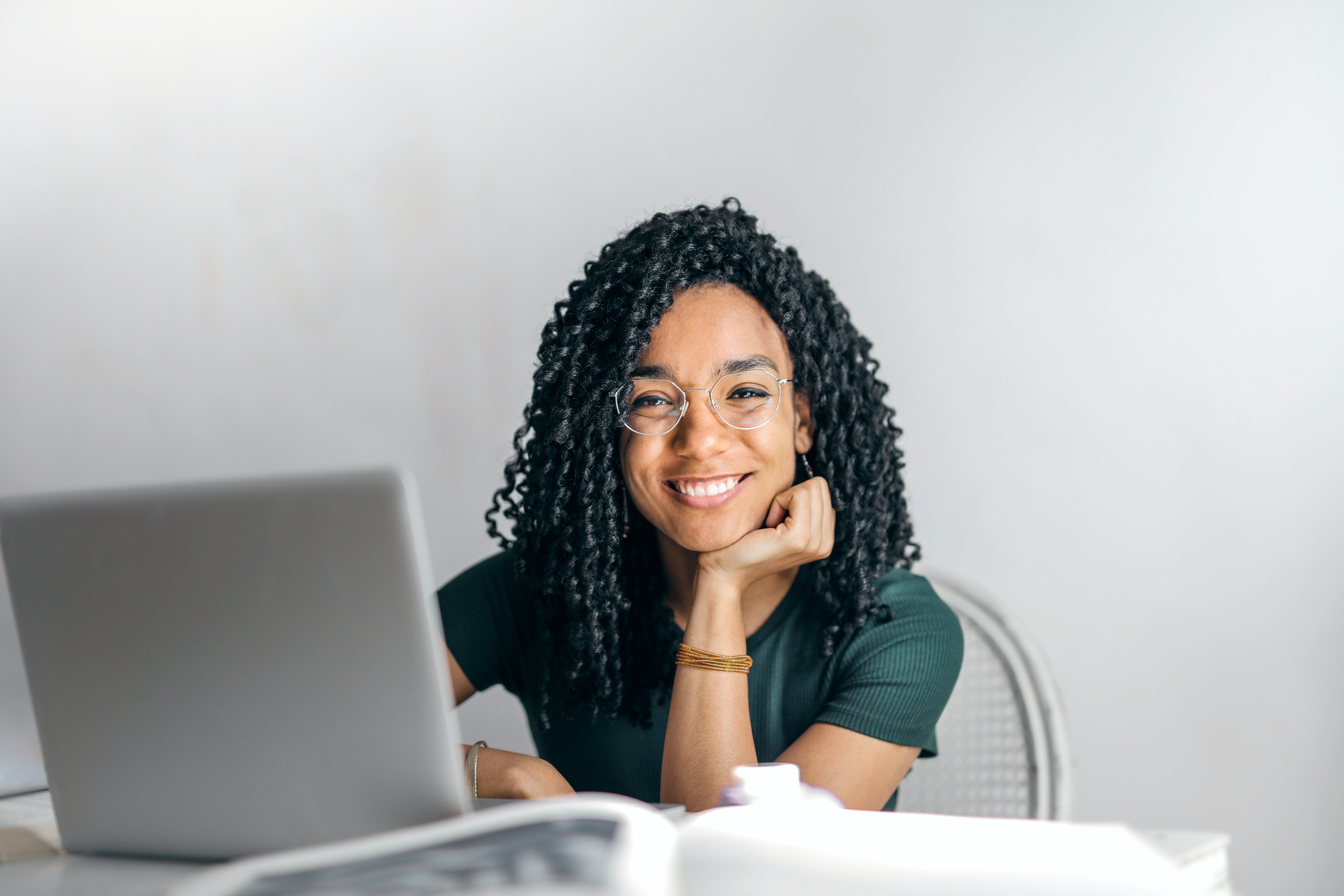 woman sitting by laptop and smiling