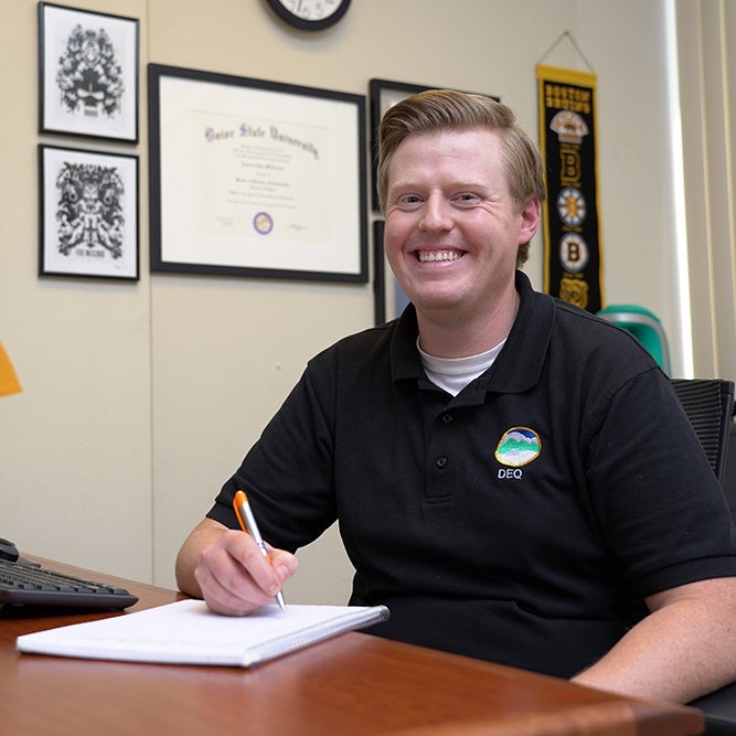 Online MBA student, Andrew McConnell, smiling while working on projects