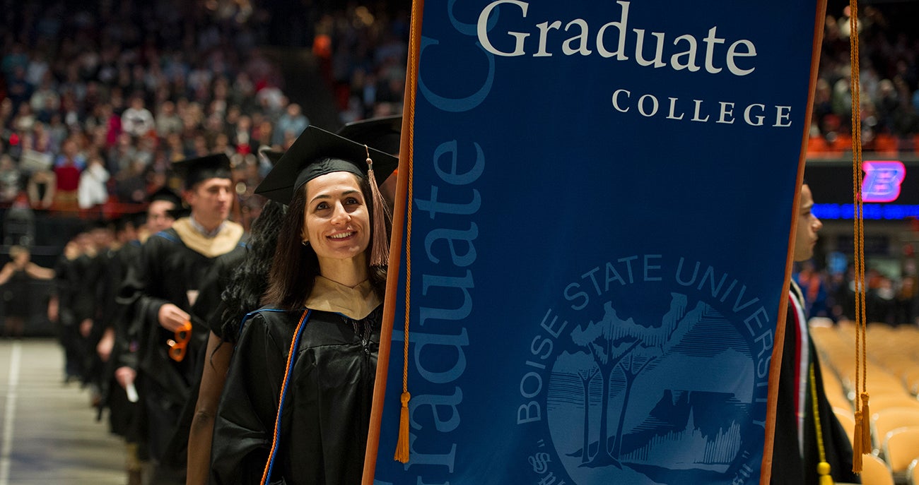 Boise State Online MBA student walking in graduation attire at commencement