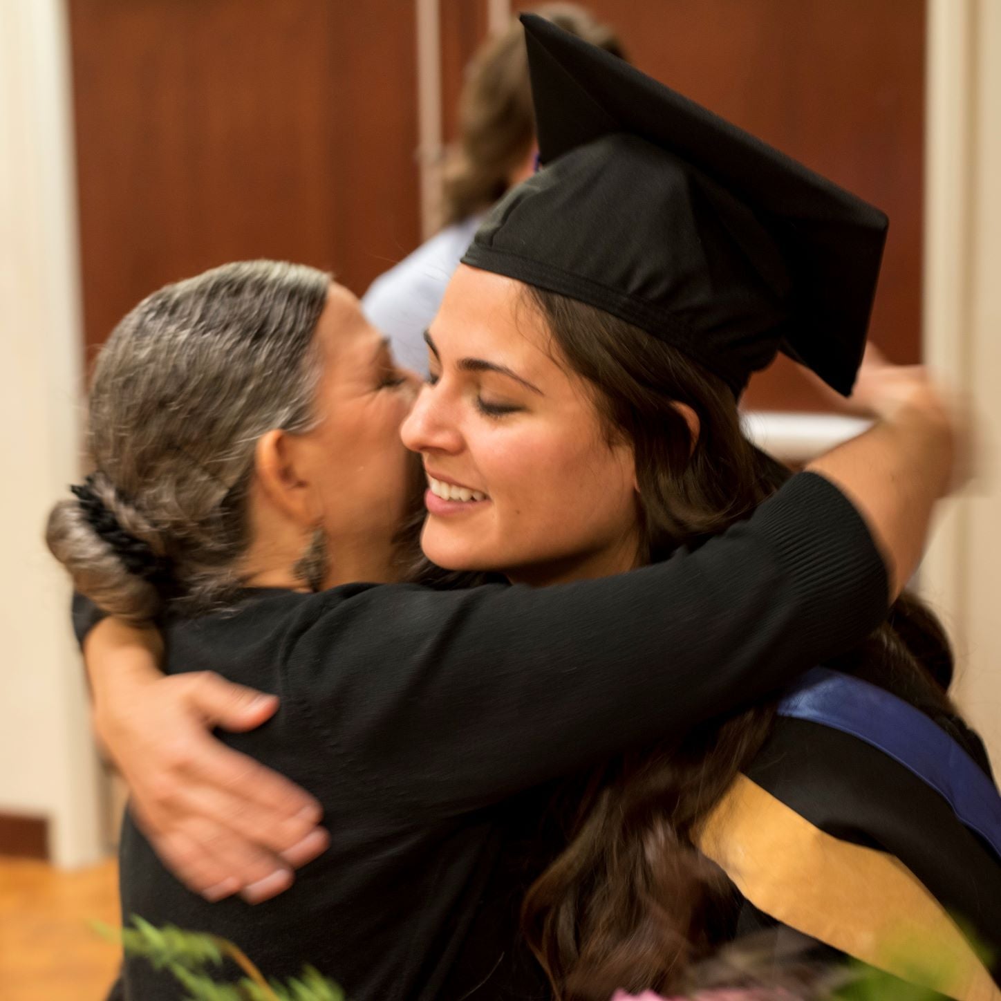 MSW graduate hugging a family member